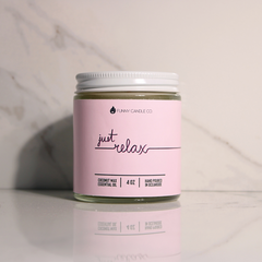 Jar of candle with pink label and white lid on a light background