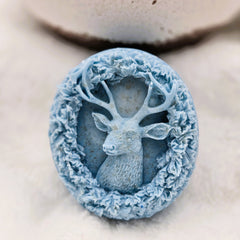 Blue stone with a deer carving on a light background