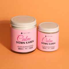 Two candles with white lids labeled 'Calm Down Karen' on an orange background