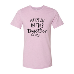 Pink t-shirt with 'We're all in this together' text on a white background