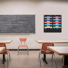 Classroom with blackboard, desks, and chairs on a beige floor. Hanging file folder on wall next to blackboard.