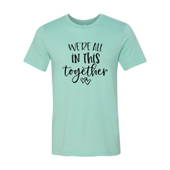 Mint green t-shirt with 'We're all in this together' text on a white background