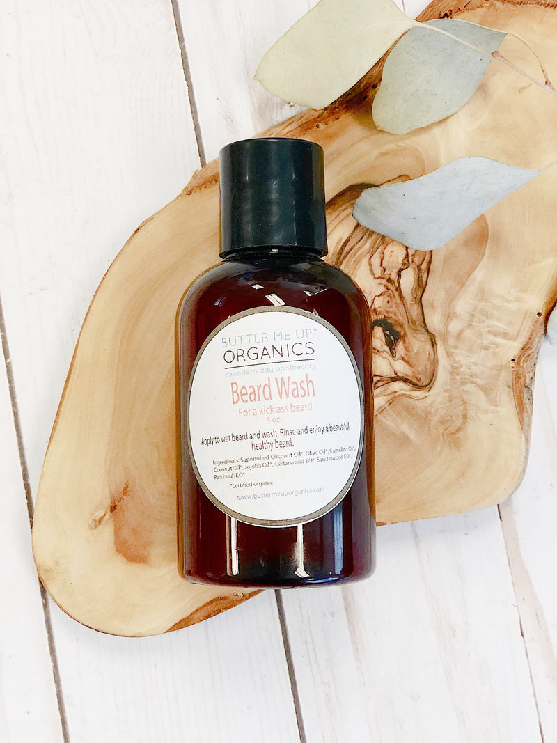 Bottle of beard wash on a wooden surface with leaves
