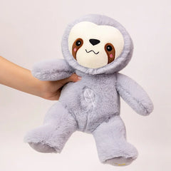 Plush toy sloth held by a hand on a light background