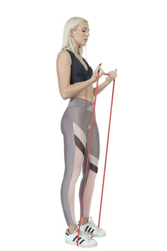 Woman exercising with a resistance band on a white background