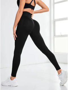 Person wearing black leggings and a sports bra on a white background
