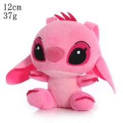 Small pink plush toy with black eyes on a white background