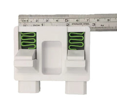 White plastic tool with green springs, measured against a ruler on a white background