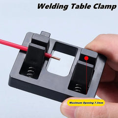 Welding table clamp held by a hand with a light background