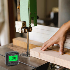 Digital timer on a workbench with a person using a bandsaw