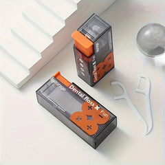 Two boxes of dental floss with orange accents on a white surface.