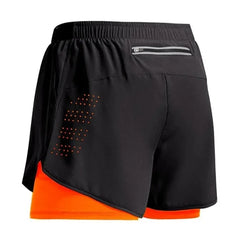 Black athletic shorts with orange lining on a white background