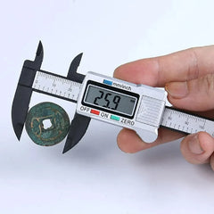 Digital caliper measuring a coin with a white background