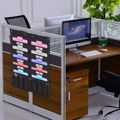 Wooden office desk with computer setup and a hanging file organizer.