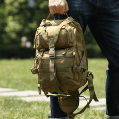 Person holding a tactical backpack outdoors