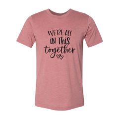 Pink t-shirt with 'We're all in this together' text on a white background