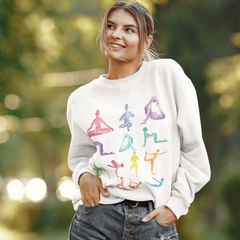 Woman wearing a white sweatshirt with colorful yoga pose illustrations outdoors.