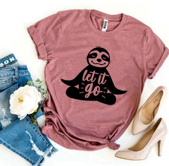 Mauve t-shirt with sloth graphic and 'let it go' text, paired with jeans and high heels on a white background.