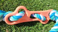 Dog toy with blue and white rope on a grass background
