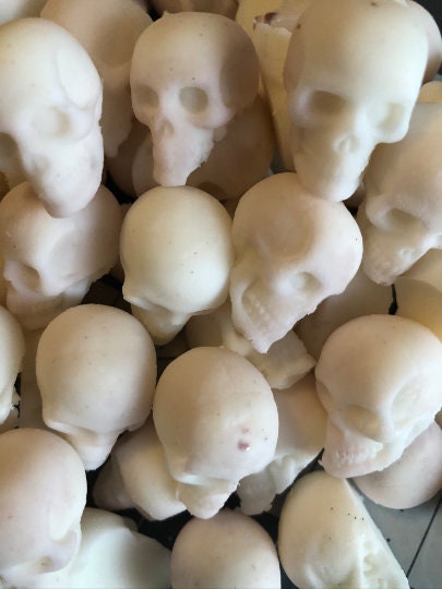 Stack of white skull-shaped objects on a dark surface