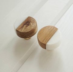 Two wooden knobs with white on a tiled floor.