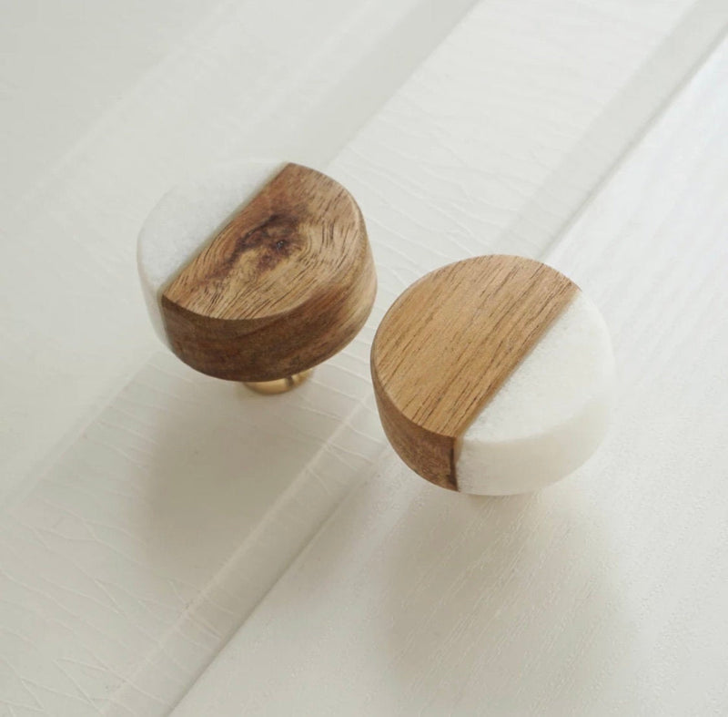 Two wooden knobs with white on a tiled floor.