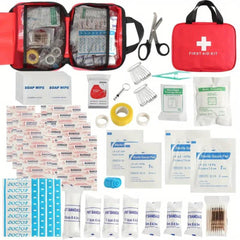 First aid kit with various supplies including bandages and scissors on a white background.