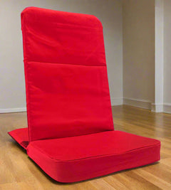 Red floor chair on a wooden floor with a plain wall background