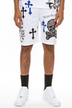 White shorts with black and blue crosses and a skull design worn by a person on a white background