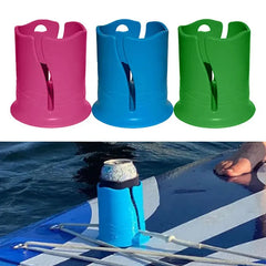 Three colorful cup holders in red, blue, and green with a blue one being used on a paddleboard.